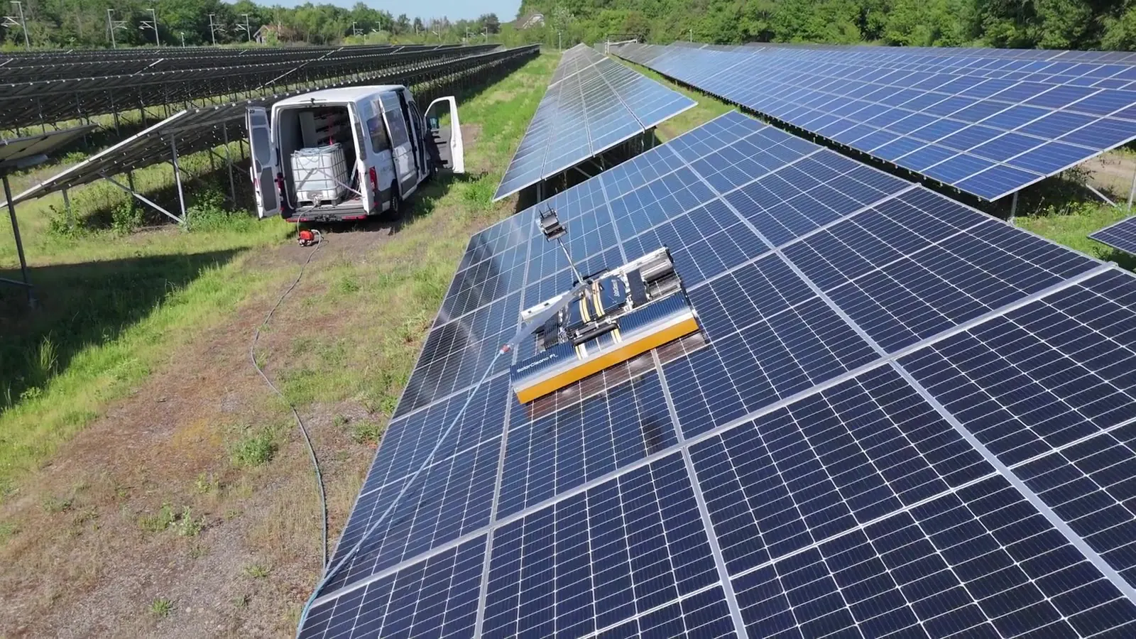 Robot SolarCleano F1 con furgoneta de servicio en una planta en suelo